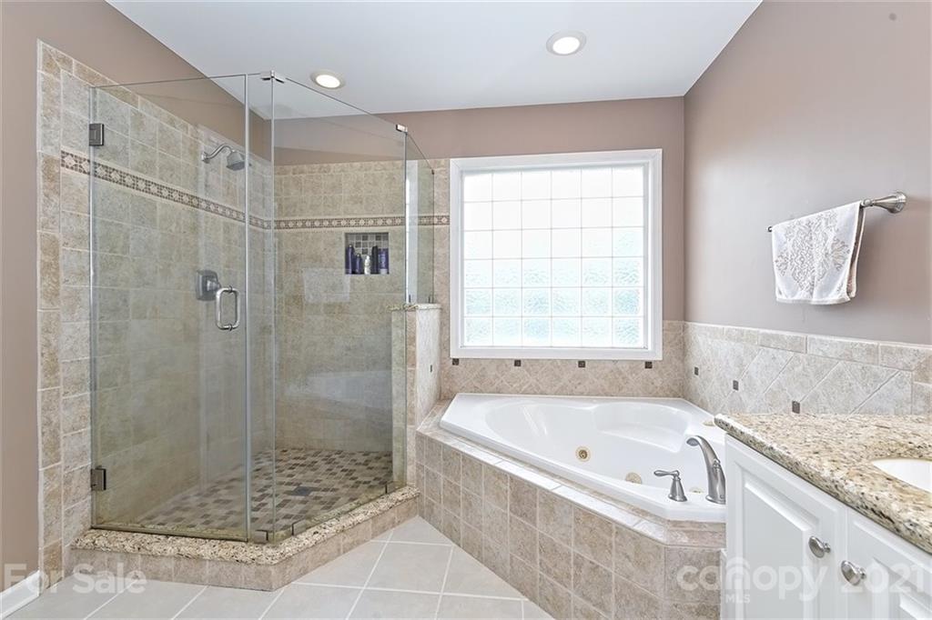 324 Gringley Hill Road Fort Mill, SC 29708 - Photo 20 of 48 a bathroom with a granite countertop bathtub a shower and a sink