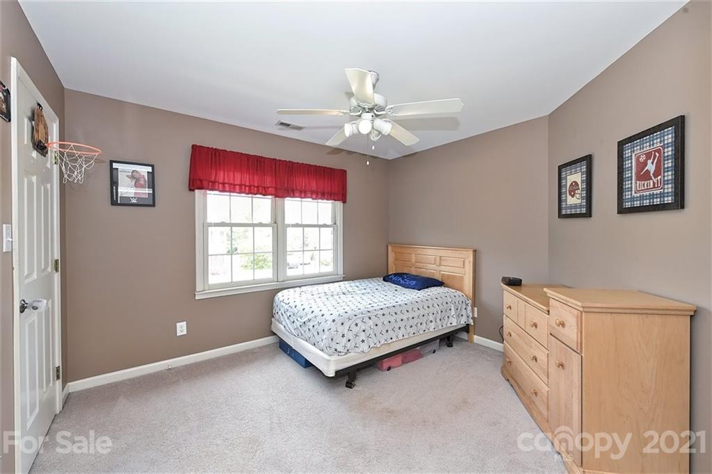 324 Gringley Hill Road Fort Mill, SC 29708 - Photo 22 of 48 a spacious bedroom with a bed and a chandelier