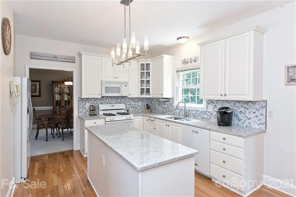 324 Gringley Hill Road Fort Mill, SC 29708 - Photo 9 of 48 a kitchen with white cabinets and chandelier