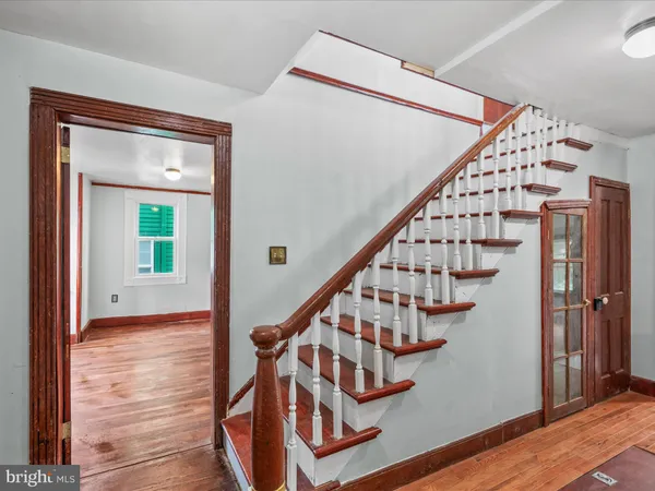 an empty room with wooden floor cabinet and windows