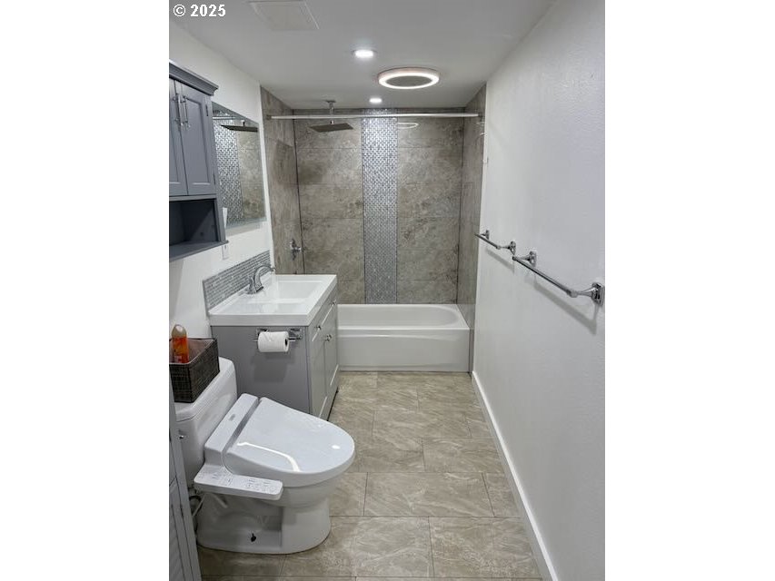 19306 Northwest 11th Avenue Ridgefield, WA 98642 - Photo 27 of 34 a white toilet sitting next to a bathroom sink and vanity