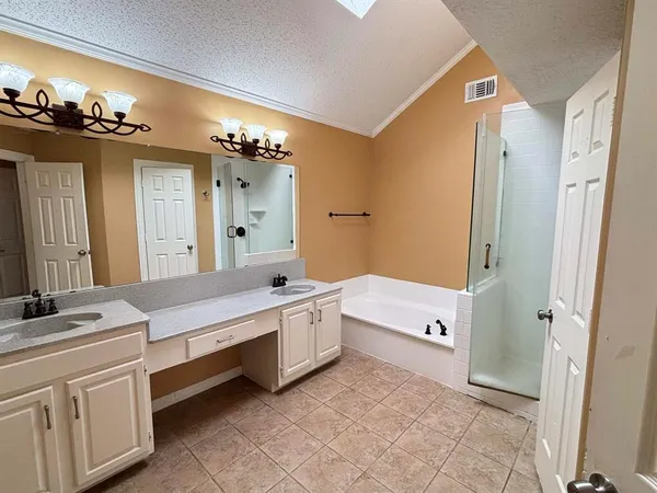 a bathroom with a tub a double vanity sink and mirror