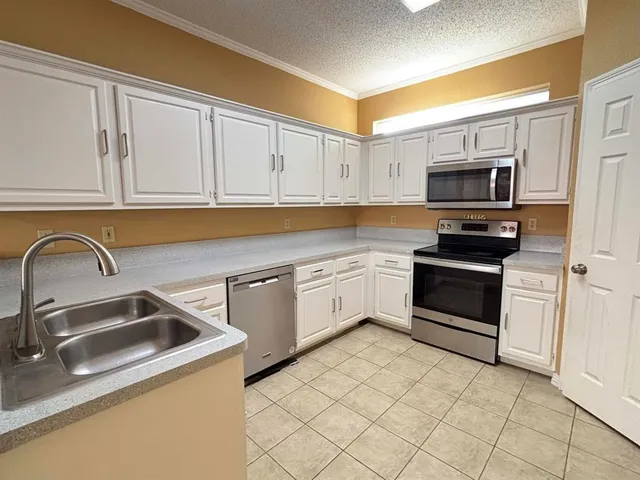 a kitchen with granite countertop a sink and white cabinets