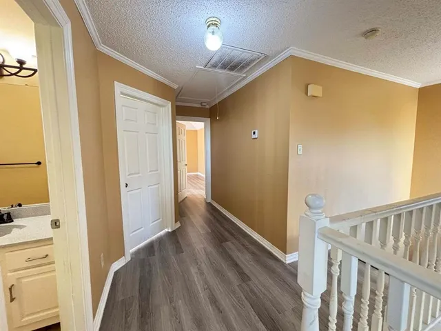 a view of a hallway to a bedroom with wooden floor