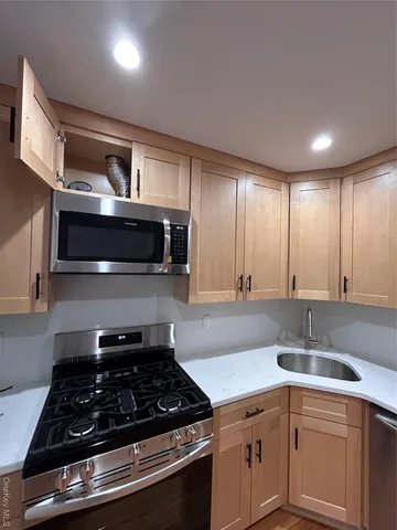 a kitchen with stainless steel appliances granite countertop a sink stove and cabinets
