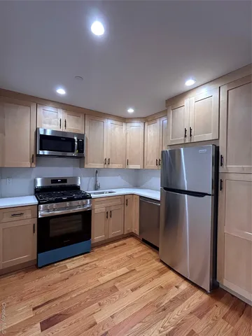 a kitchen with stainless steel appliances granite countertop a refrigerator sink and stove