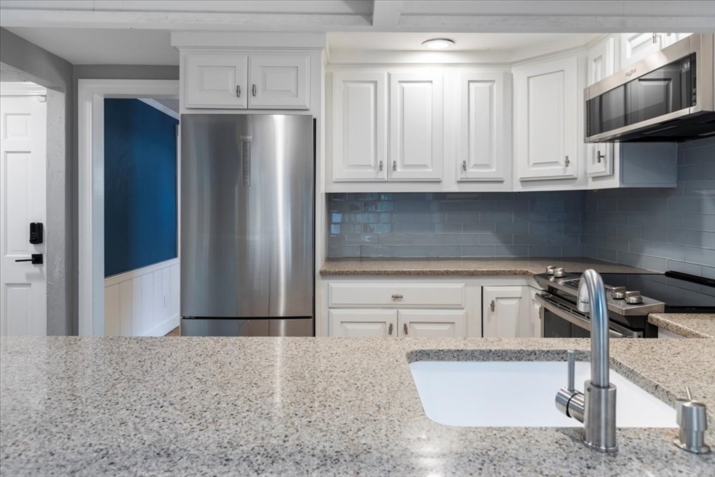 5 Windsor Road Stoneham, MA 02180 - Photo 11 of 37 a kitchen with stainless steel appliances granite countertop a refrigerator a stove and a sink