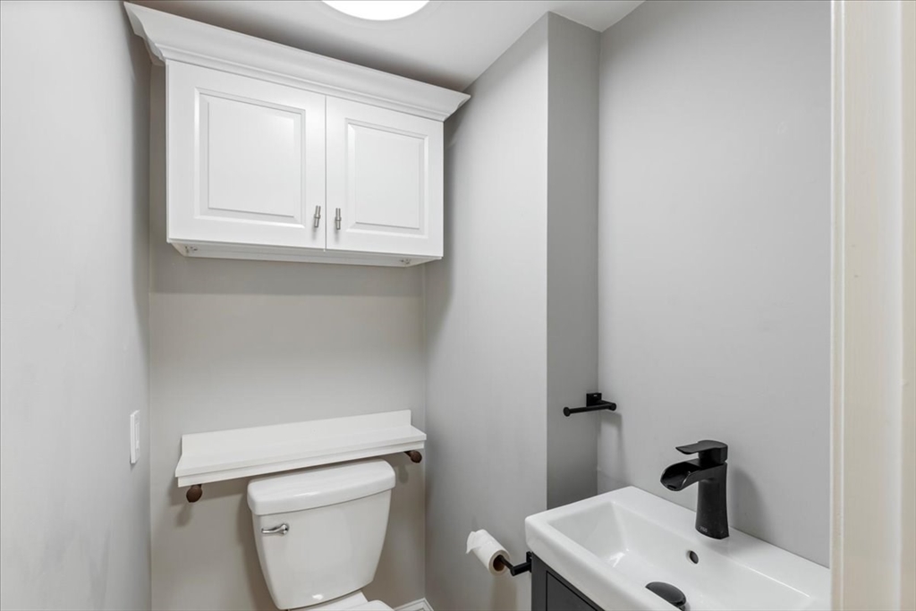 5 Windsor Road Stoneham, MA 02180 - Photo 16 of 37 a bathroom with a toilet sink and mirror