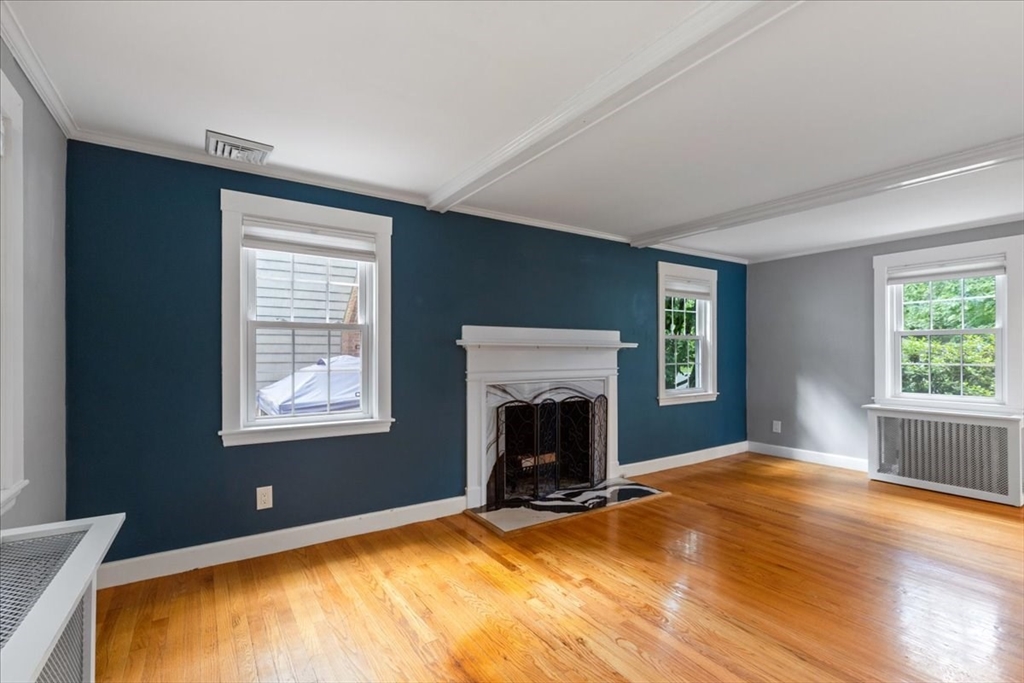 5 Windsor Road Stoneham, MA 02180 - Photo 5 of 37 a view of empty room with wooden floor and fireplace