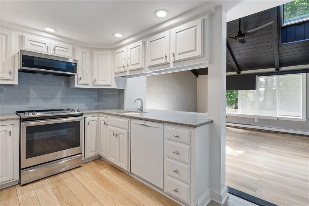 5 Windsor Road Stoneham, MA 02180 - Photo 9 of 37 a kitchen with stainless steel appliances granite countertop a stove a sink and a microwave