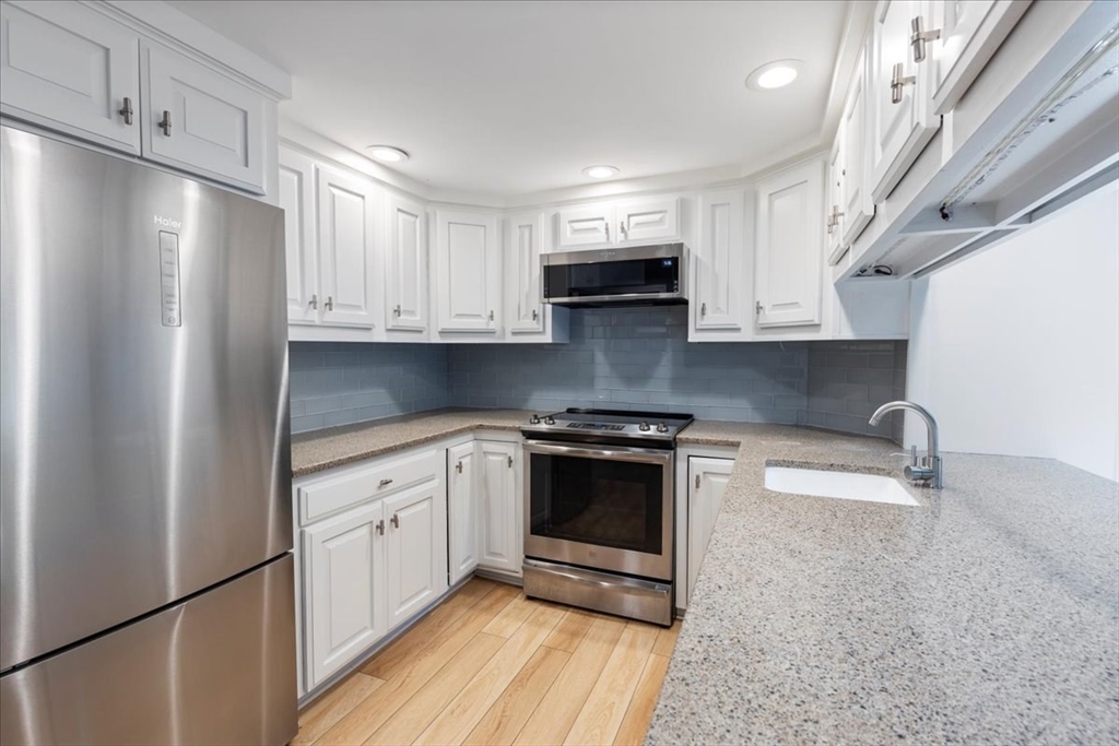 5 Windsor Road Stoneham, MA 02180 - Photo 10 of 37 a kitchen with stainless steel appliances granite countertop a refrigerator sink and stove