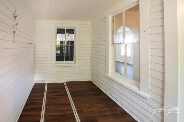 a view of a livingroom with wooden floor and a large window