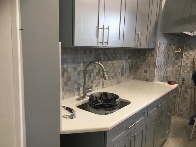 a kitchen with a sink a stove and cabinets