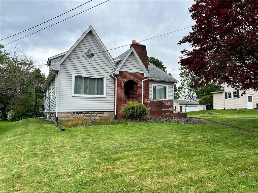 a front view of a house with yard and green space