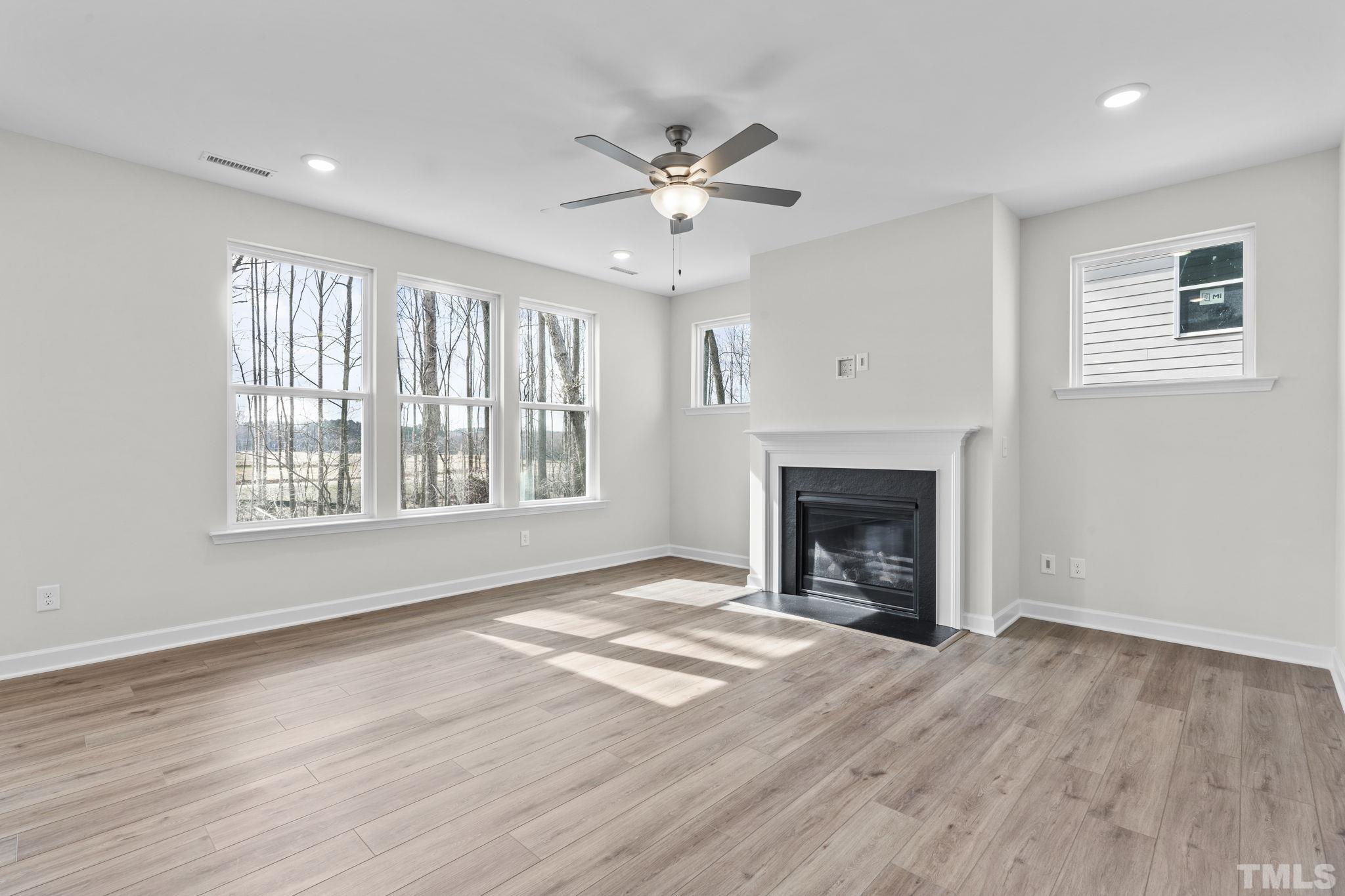 516 Craftsman Rdg Trail Knightdale, NC 27545 - Photo 12 of 45 a view of an empty room with wooden floor fireplace and a window