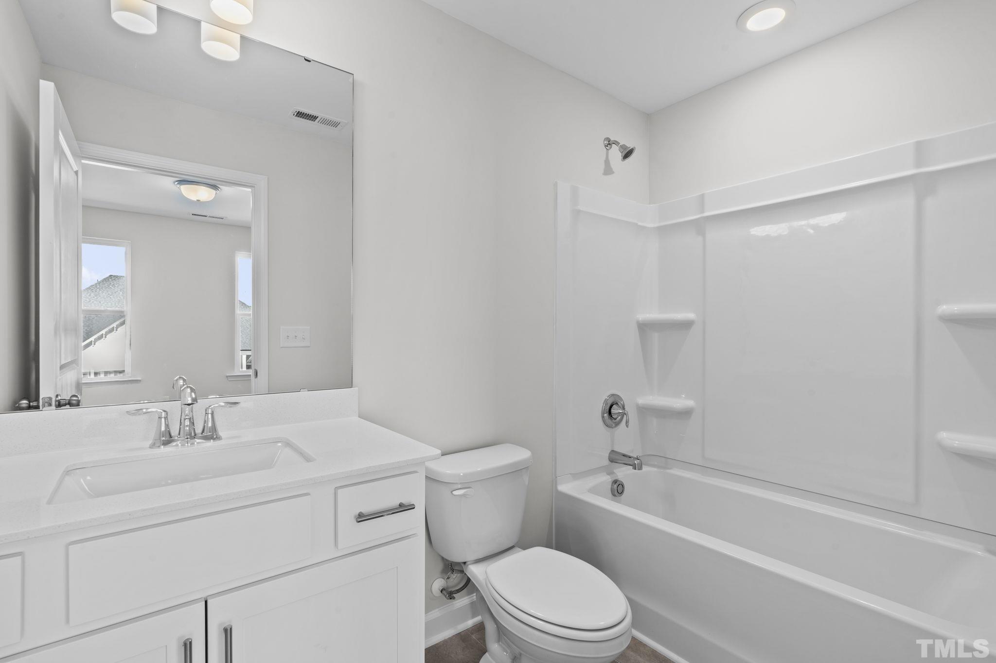 516 Craftsman Rdg Trail Knightdale, NC 27545 - Photo 26 of 45 a bathroom with a toilet a sink a mirror a bathtub and vanity