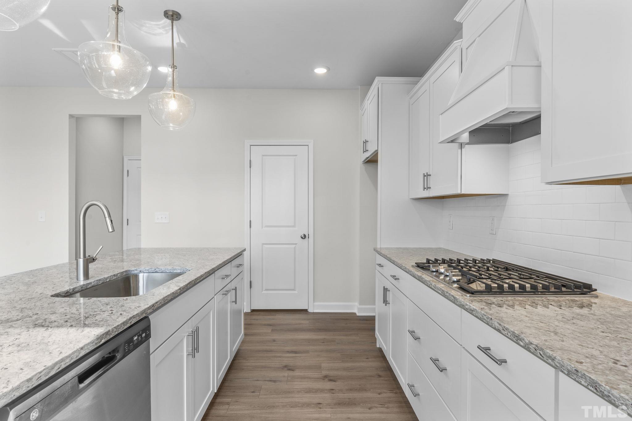 516 Craftsman Rdg Trail Knightdale, NC 27545 - Photo 8 of 45 a kitchen with stainless steel appliances granite countertop a sink stove and cabinets
