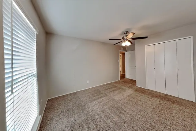 a view of a livingroom with a ceiling fan and window