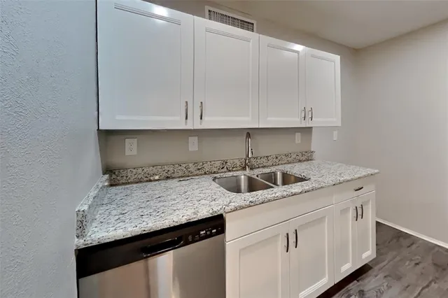 a kitchen with granite countertop a sink and cabinets