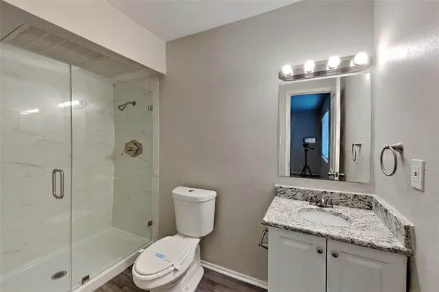 a bathroom with a granite countertop sink toilet and shower