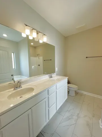 a spacious bathroom with a double vanity sink mirror and toilet