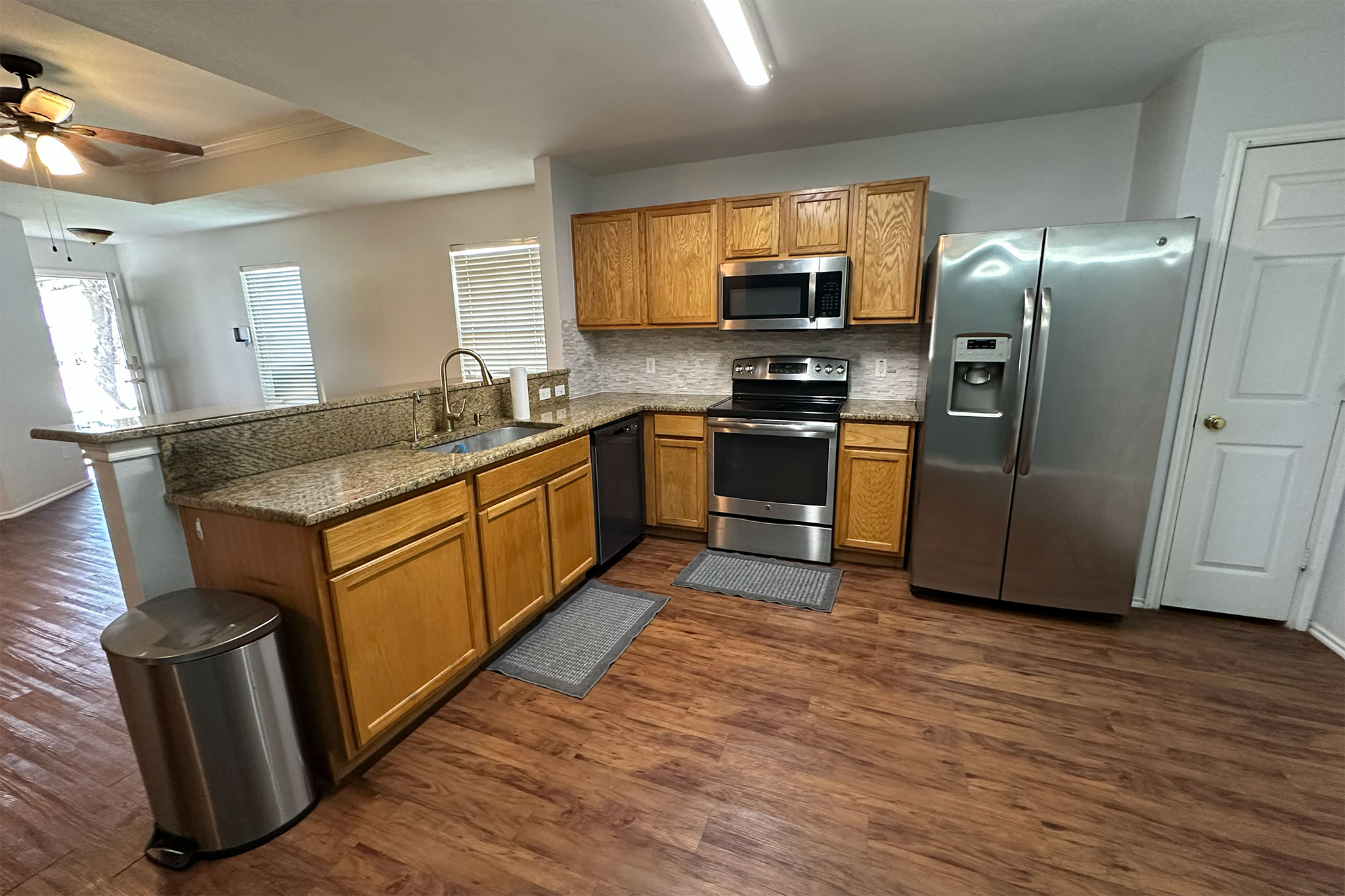 3309 Crownover Street Austin, TX 78725 - Photo 2 of 12 a kitchen with stainless steel appliances granite countertop a sink a stove a refrigerator cabinets and wooden floor