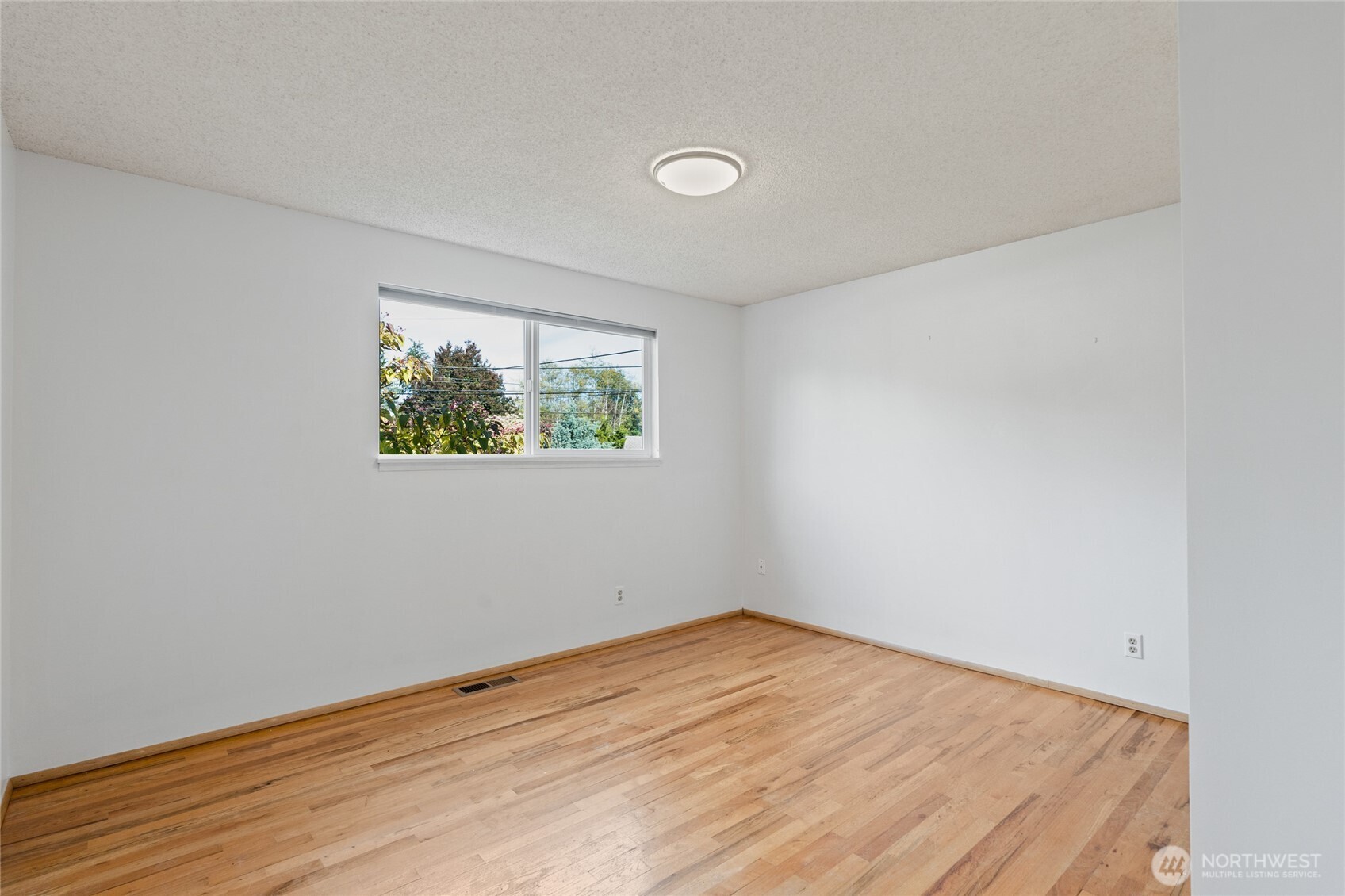 8506 224th Street Southwest Edmonds, WA 98026 - Photo 16 of 19 an empty room with wooden floor and window