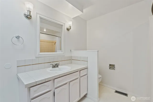 a bathroom with a sink toilet and mirror