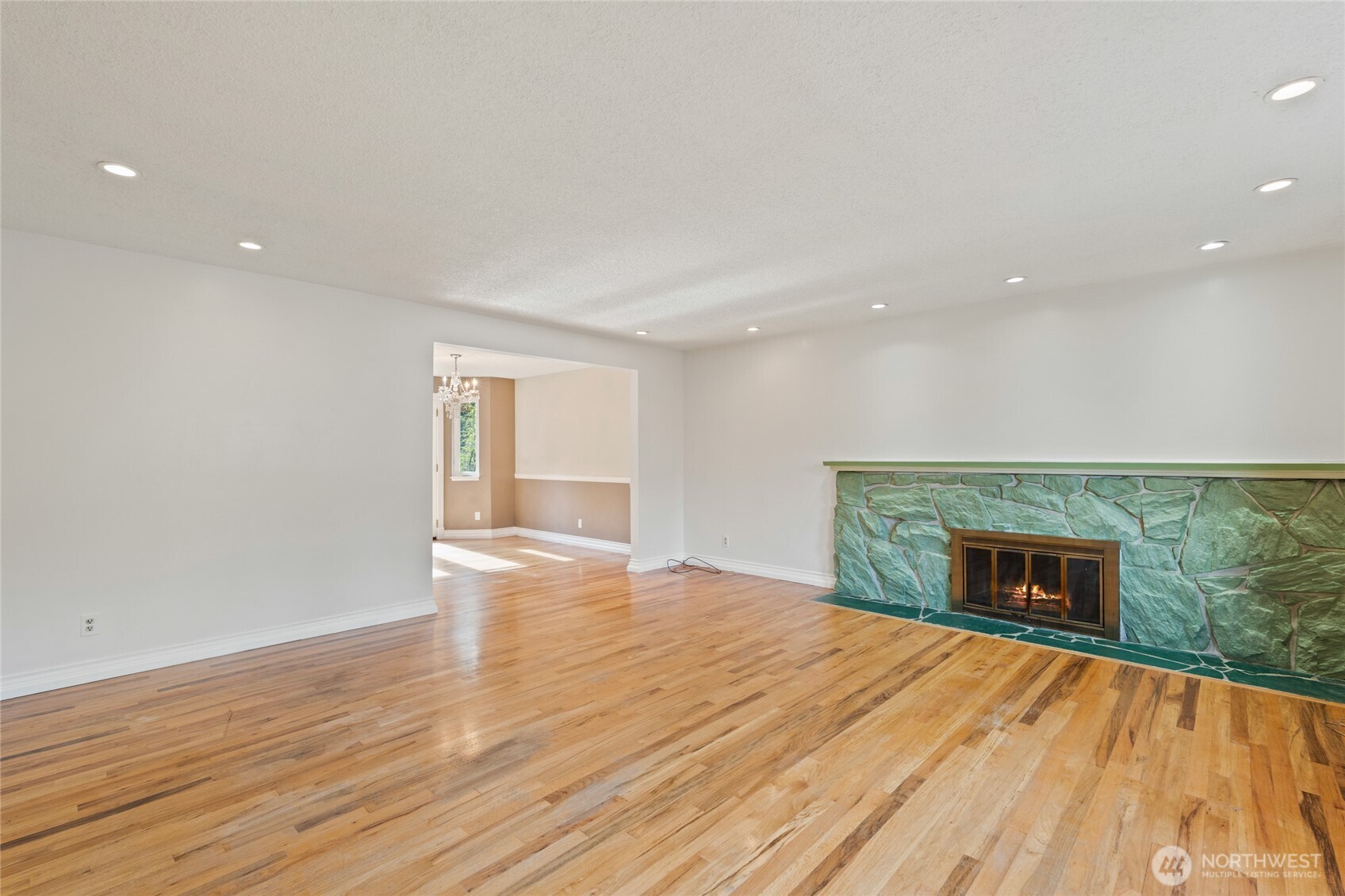 8506 224th Street Southwest Edmonds, WA 98026 - Photo 3 of 19 an empty room with wooden floor fireplace and windows