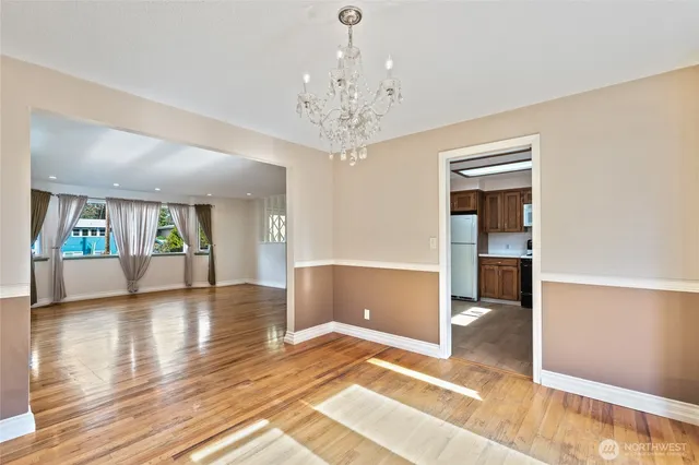 a view of an empty room with wooden floor and a large window