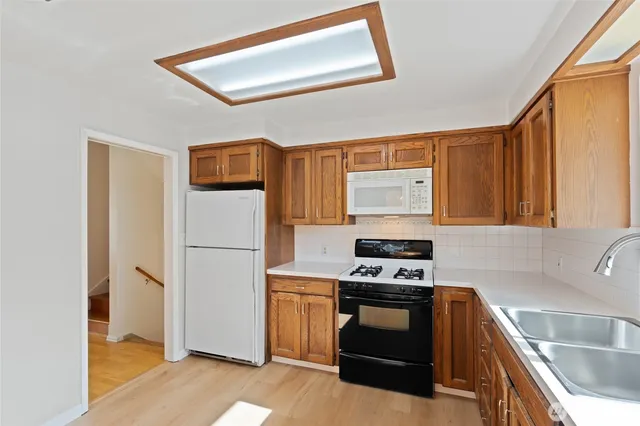 a kitchen with a stove a refrigerator and a sink