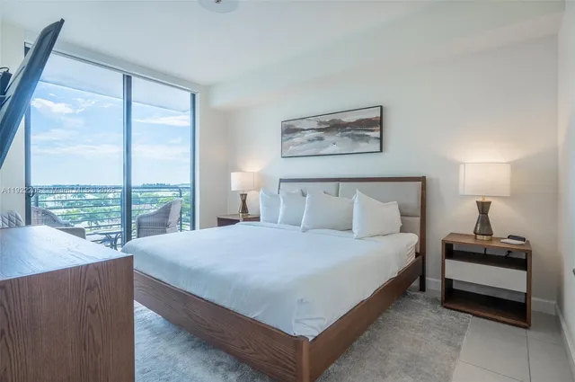 a bedroom with a bed and a large window