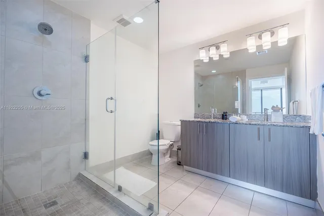 a bathroom with a glass shower door and a sink