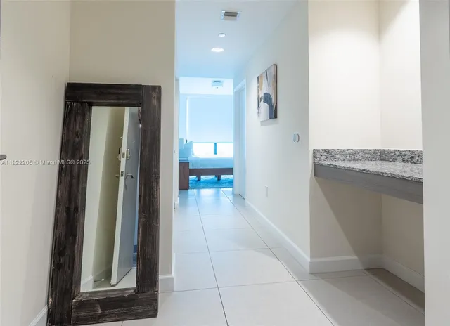a view of a hallway with wooden floor and a living room