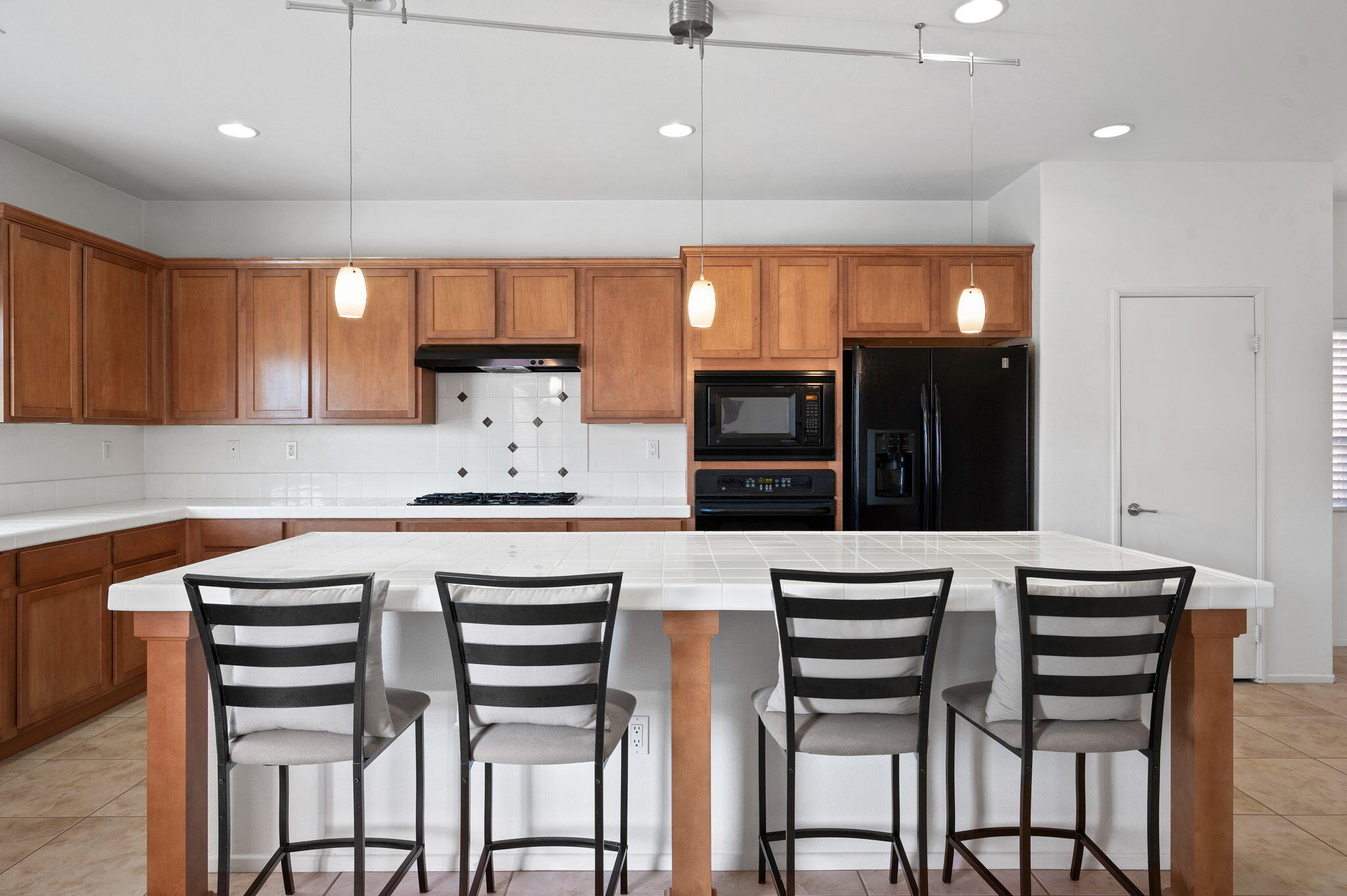 82809 Larsen Drive Indio, CA 92203 - Photo 11 of 34 a kitchen with a table chairs refrigerator and microwave