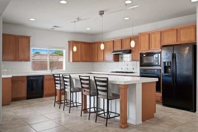 a kitchen with stainless steel appliances granite countertop a stove refrigerator sink and cabinets
