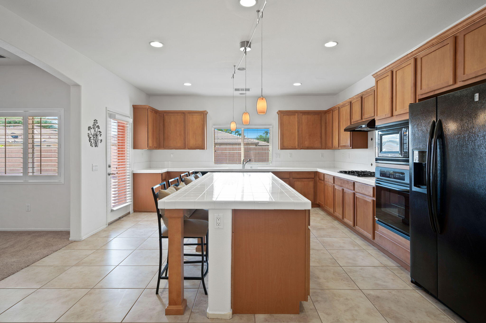82809 Larsen Drive Indio, CA 92203 - Photo 9 of 34 a kitchen with stainless steel appliances granite countertop a sink a stove a refrigerator and island