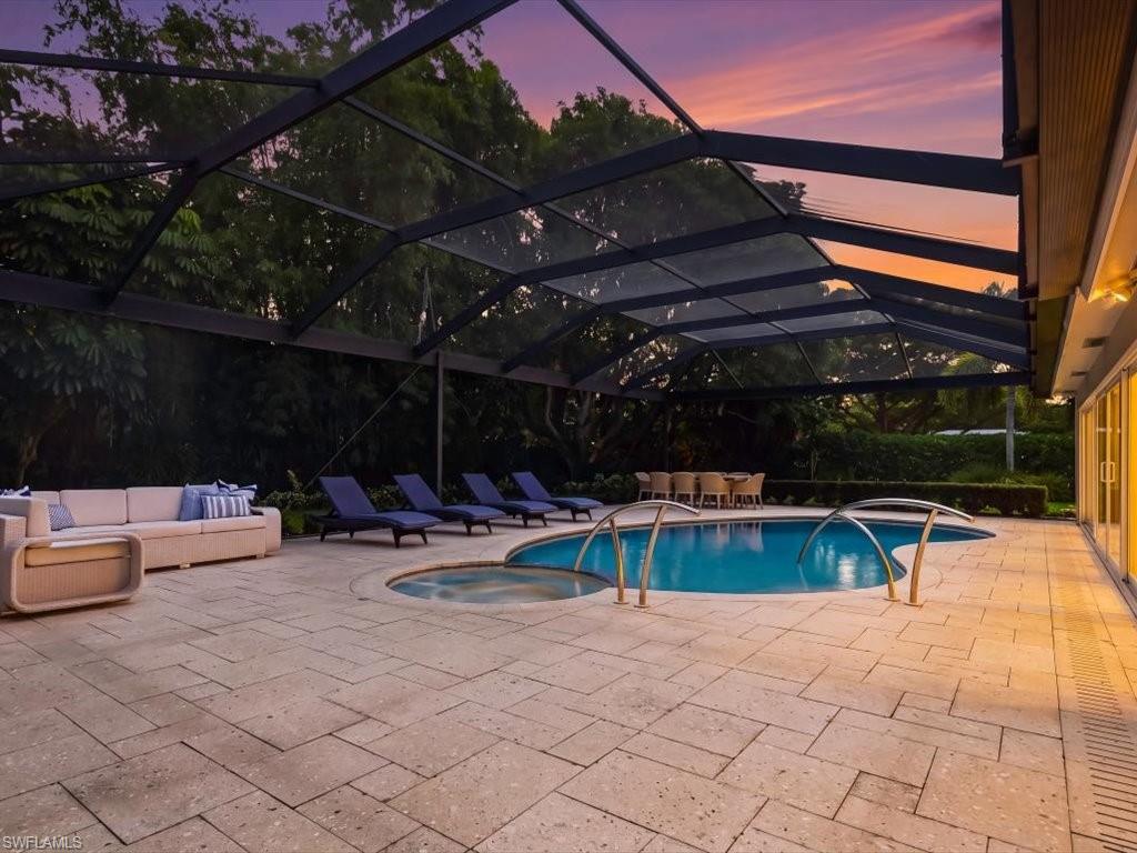 1390 Mandarin Road Naples, FL 34102 - Photo 22 of 50 Screened outdoor living area featuring a freeform swimming pool, integrated spa, and expansive paver patio