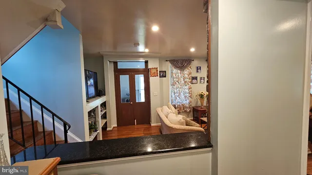 a living room with hard wood floors and a bed