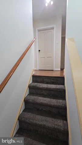 a view of a white house with a big yard and large trees