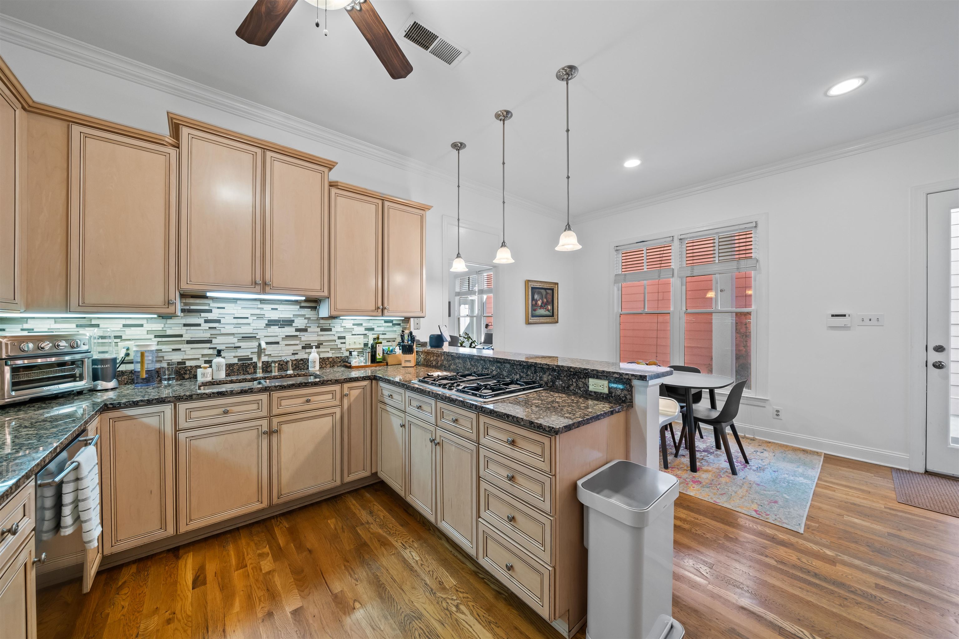 556 Rienzi Drive Memphis, TN 38103 - Photo 10 of 31 a kitchen with stainless steel appliances granite countertop hardwood floor sink stove dining table and chairs