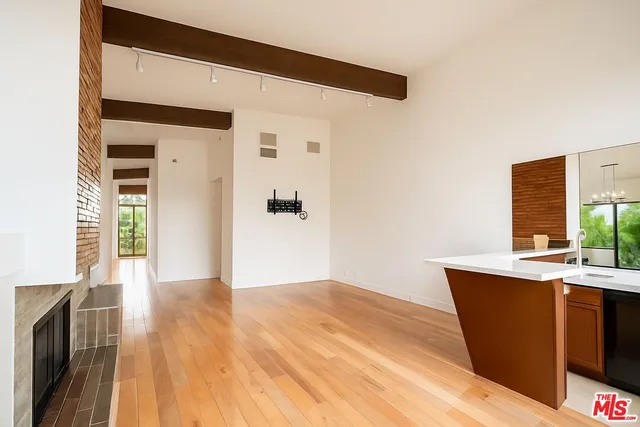 a view of a kitchen with wooden floor and a sink