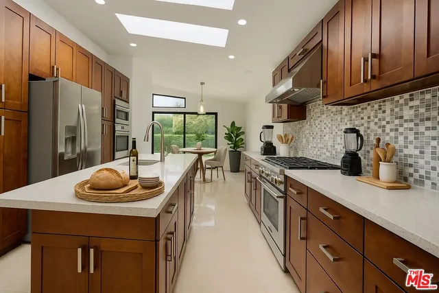 a kitchen with stainless steel appliances granite countertop a sink a stove and a refrigerator