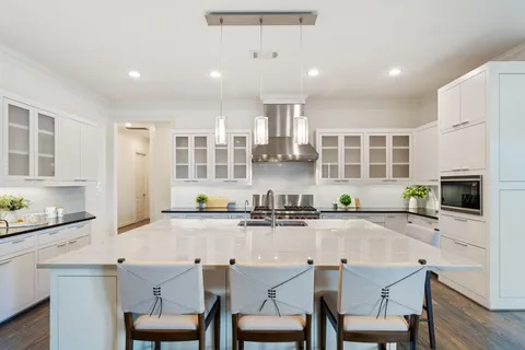 a kitchen with granite countertop a sink chairs and wooden floor