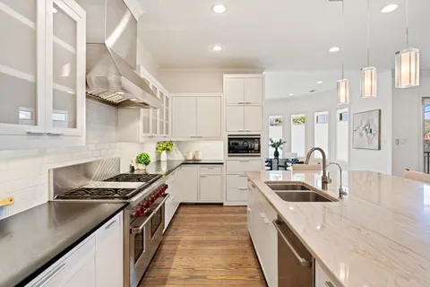 a kitchen with stainless steel appliances granite countertop a sink stove and refrigerator