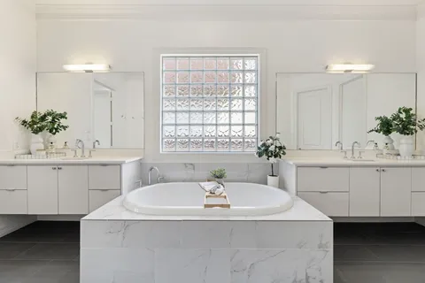 a bathroom with a sink a tub and a mirror