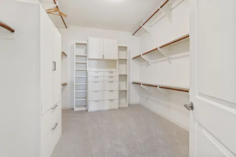 a view of walk in closet with empty racks