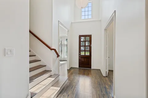 a view of a hallway with wooden floor and entryway