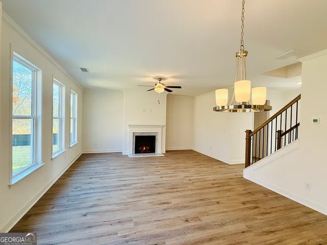 a view of empty room with wooden floor and fireplace