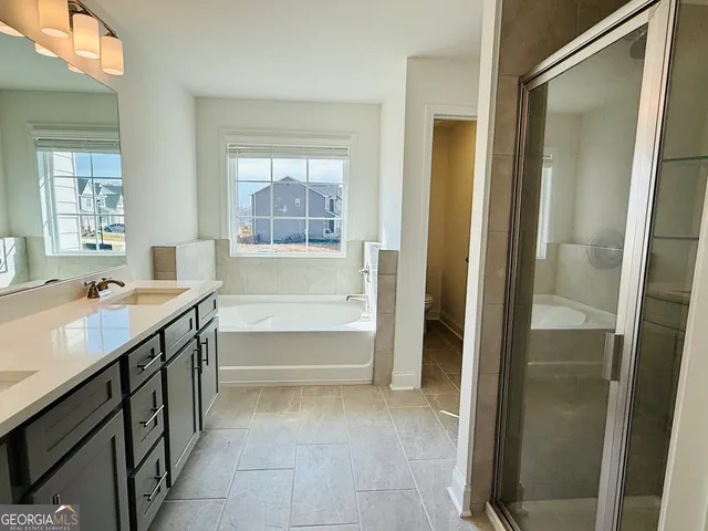 a bathroom with a granite countertop sink mirror and a bathtub